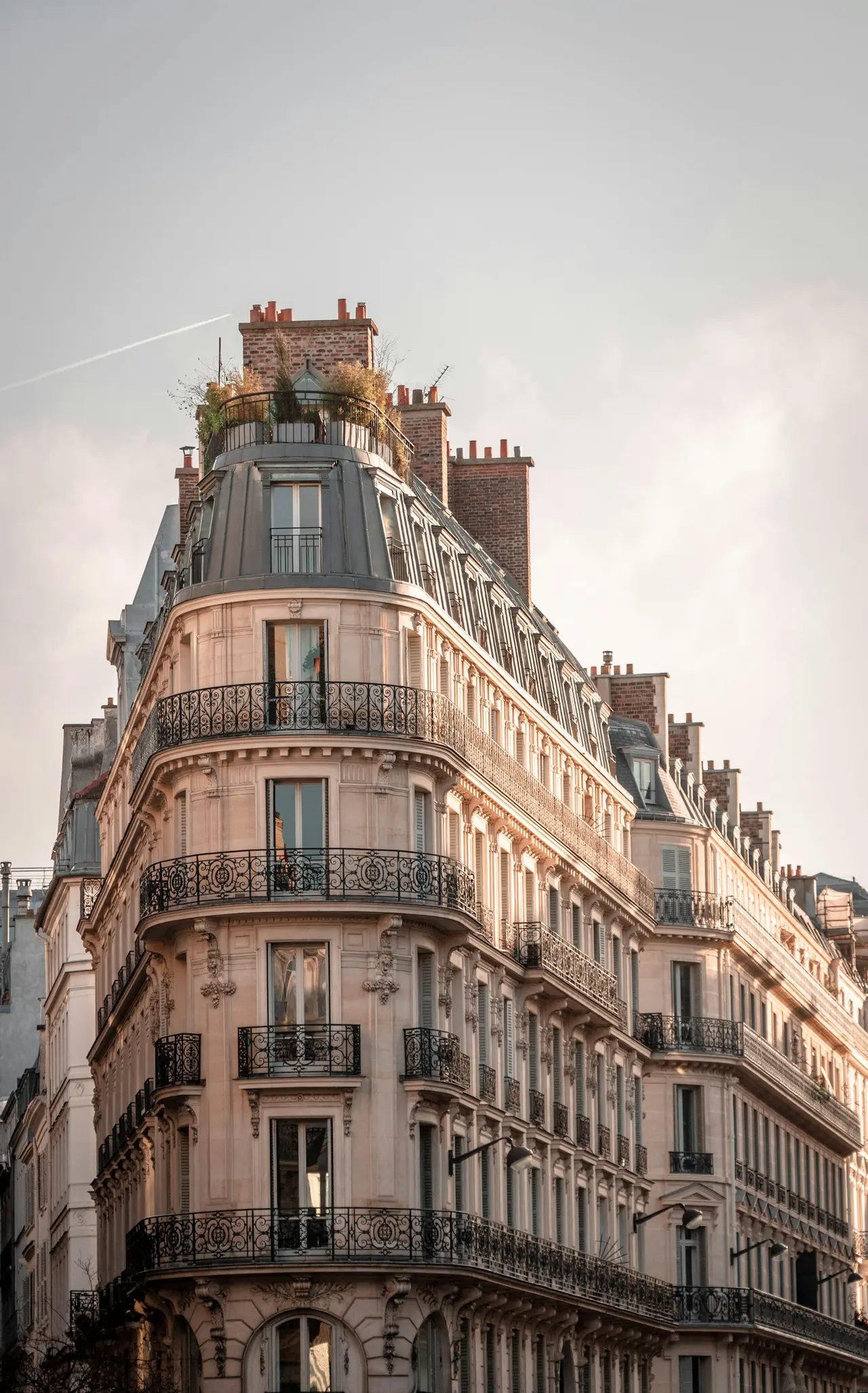 Façade d’immeuble haussmannien parisien avec balcons en fer forgé
