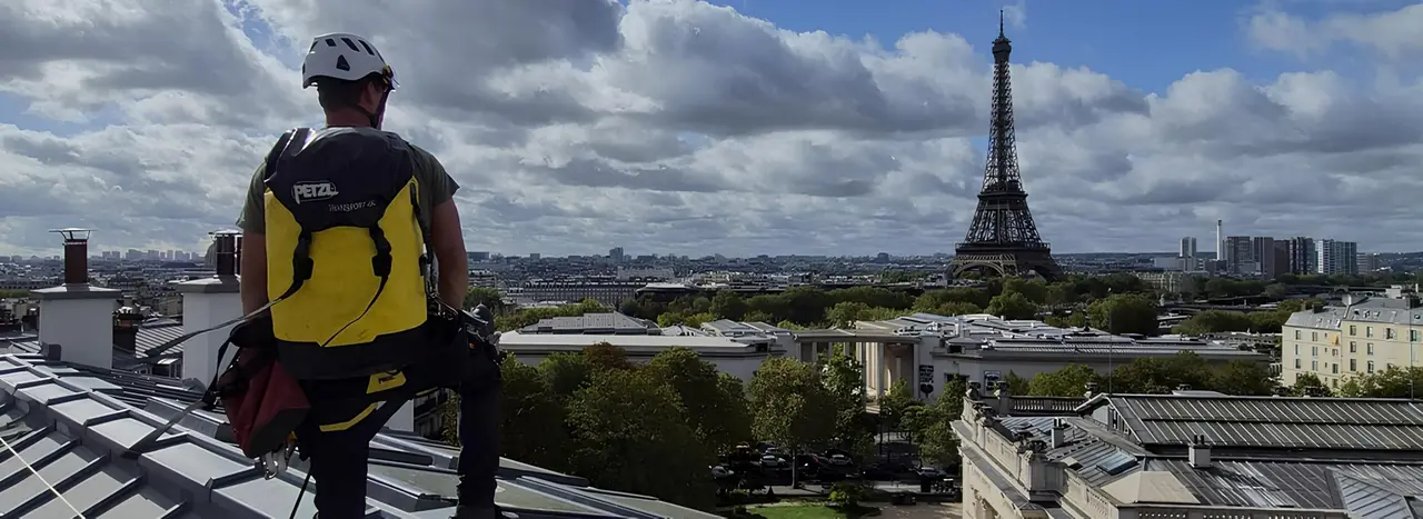Cordiste JF Accès de dos sur un toit parisien, face à la tour Eiffel